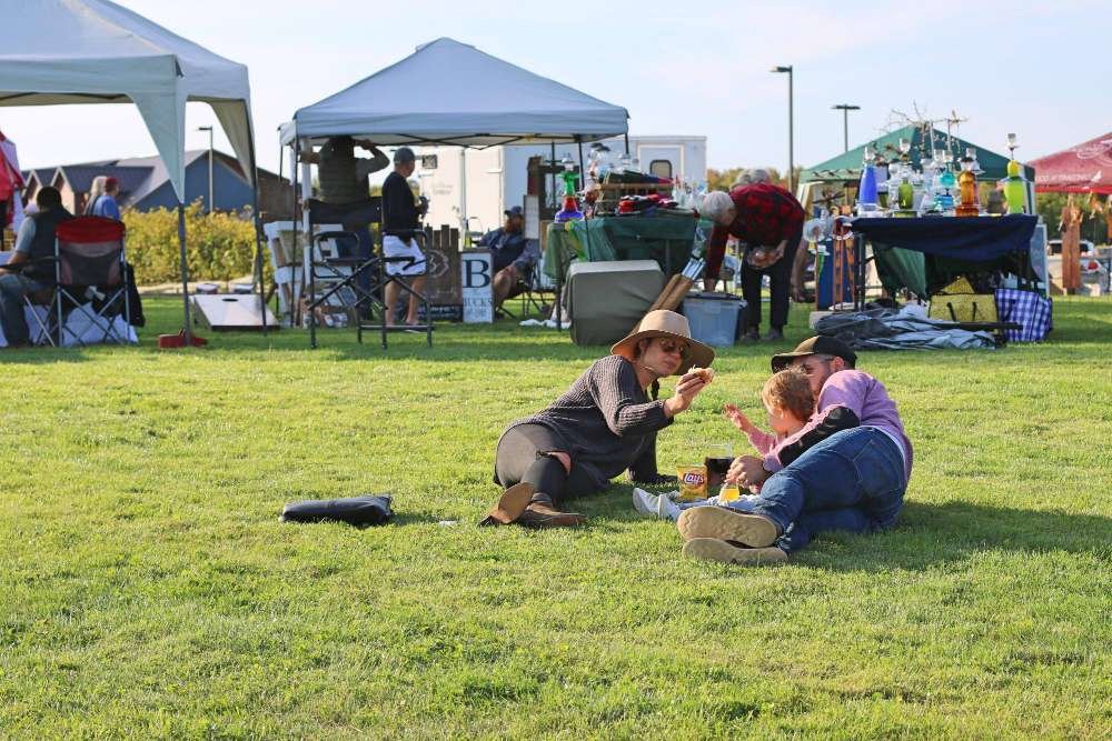 A couple with child enjoying the sunny day at Dancing Dragonfly's Grape Stomp Festival